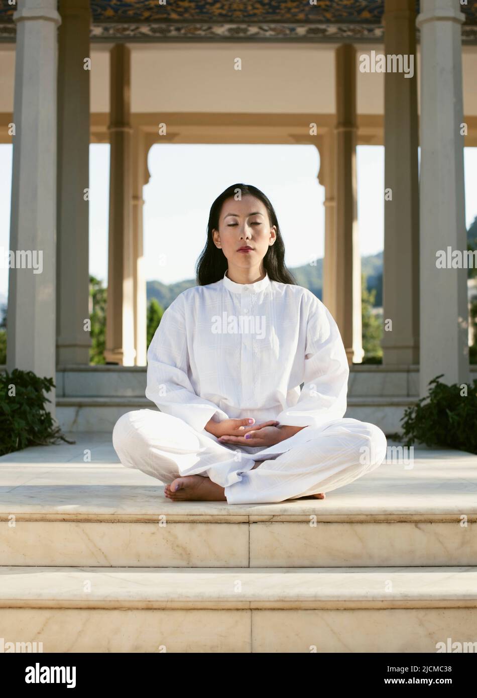 A young woman practices early morning meditation. Stock Photo