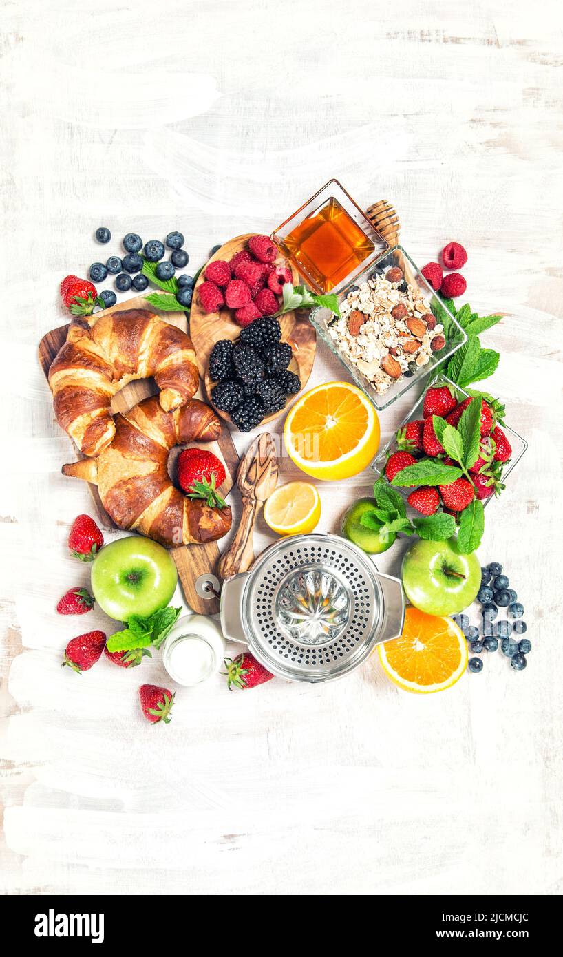 Breakfast table croissants, fresh berries, fruits. Healthy food and drink Stock Photo