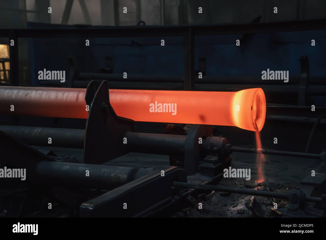 Freshly cast hot cast iron pipes at smelter. Manufacture of pipes for