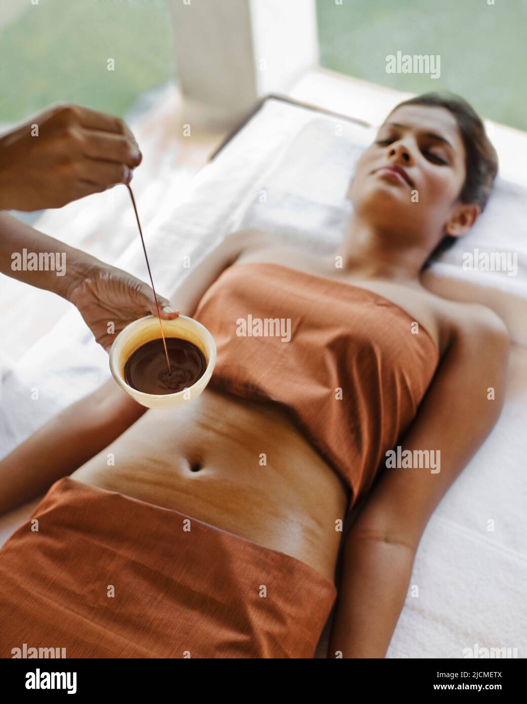 A woman receives Dark Chocolate massage and skin treatment at a spa in Sri Lanka. Stock Photo