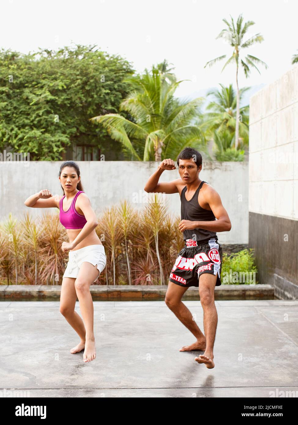 A young woman trains with a Muay Thai instructor. Phuket, Thailand. Stock Photo