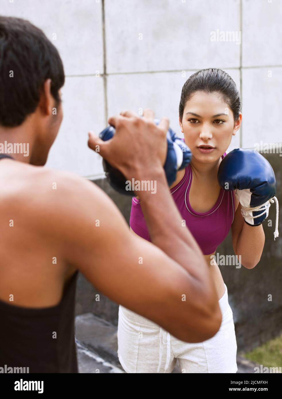 A young woman trains with a Muay Thai instructor. Phuket, Thailand. Stock Photo