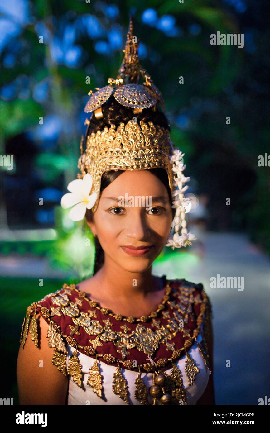 A young Cambodian Apsara dancer walks on a pathway at dusk. Siem Reap, Cambodia. An Apsara dancer is a classical Khmer dancer. Stock Photo