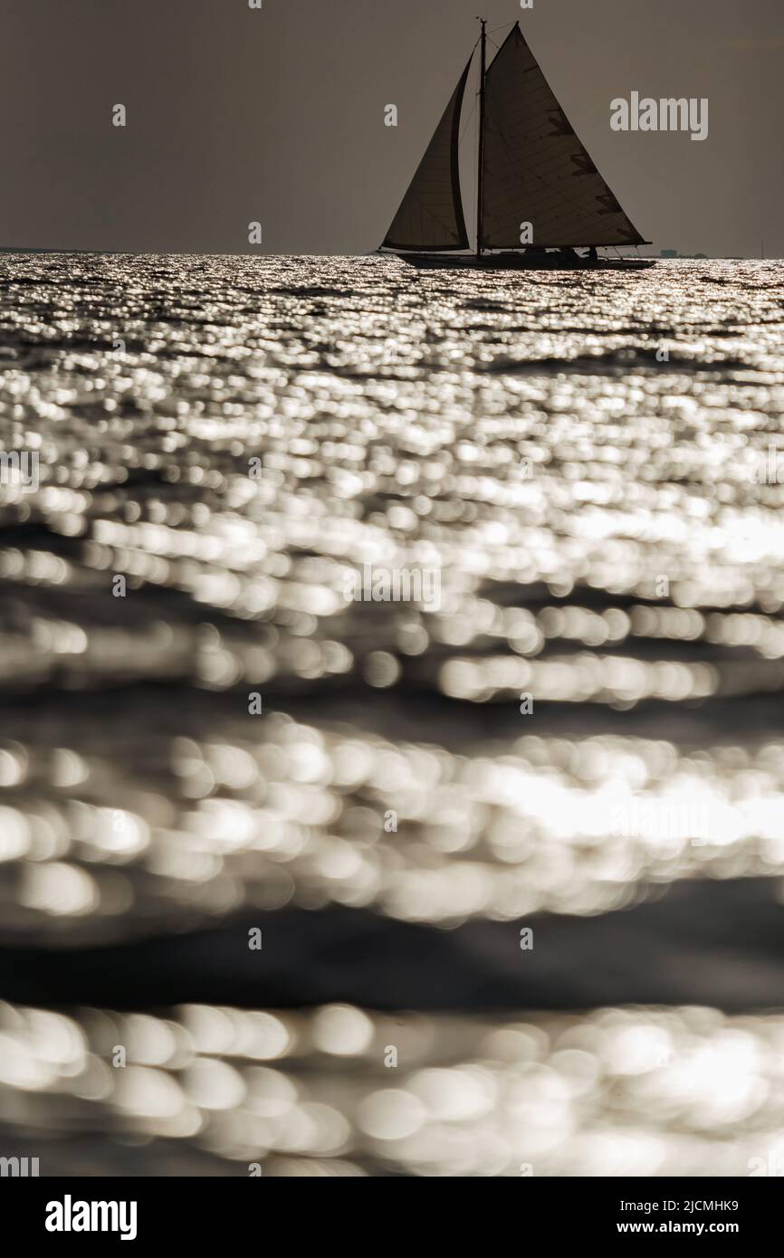 Classic sailing yacht in sea at sunset, the clear sky, sun reflection ...