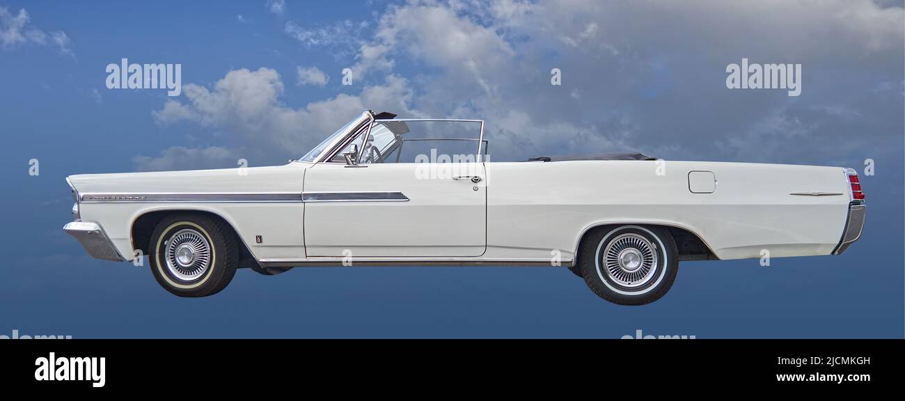 Pontiac Parisienne convertible in white, cropped classic automobile in side view against blue background with clouds in Hildesheim, Germany, May 21, 2 Stock Photo