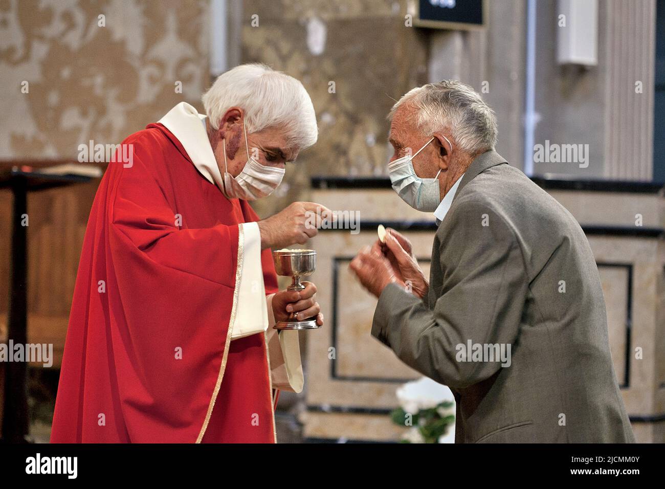 Elderly man receiving host from priest, Catalonia. Stock Photo