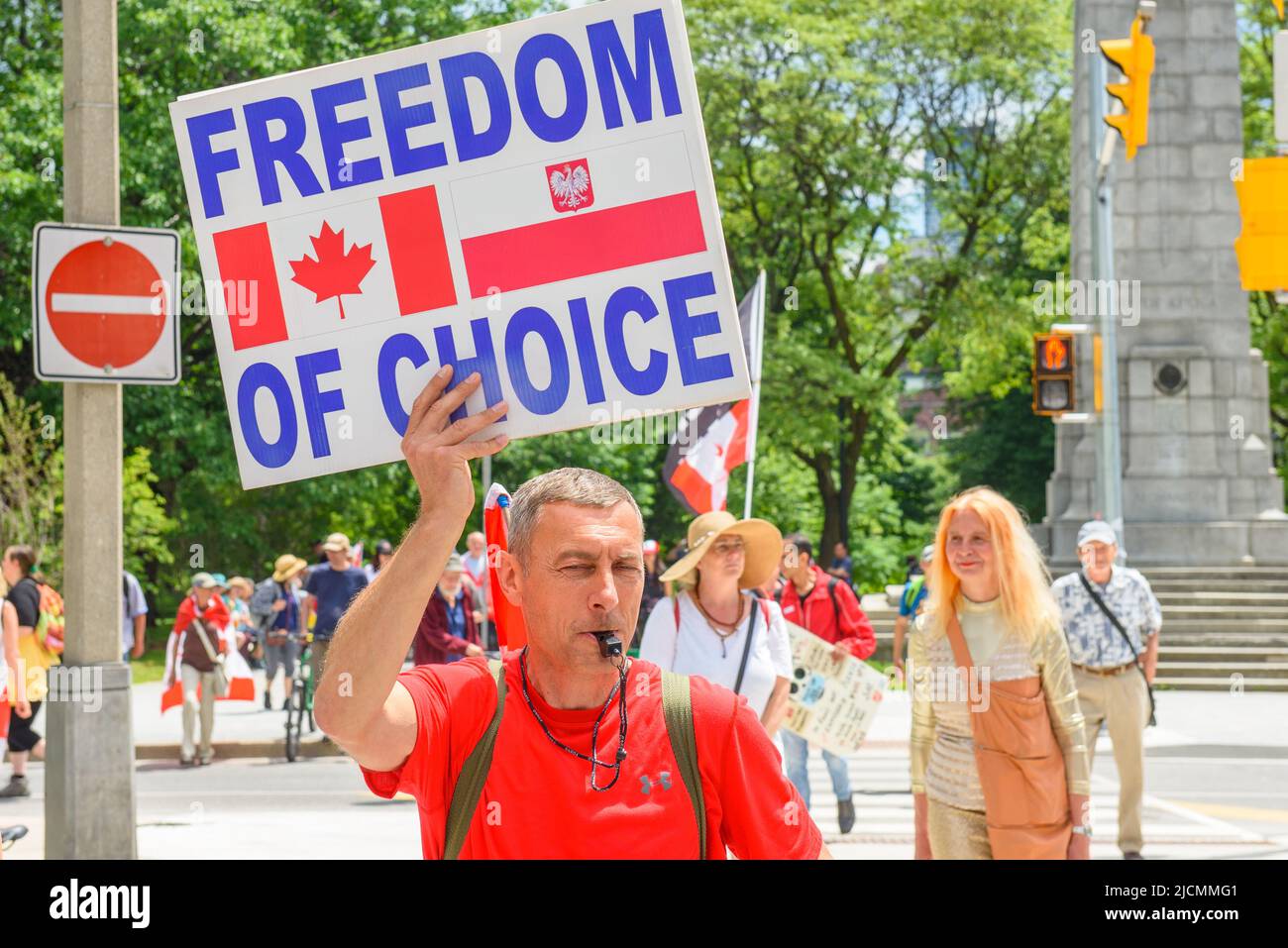 People protest during the Word On The Street Festival in Queen's Park Circle. A man holds a sign reading 'Freedom of Choice'. Stock Photo