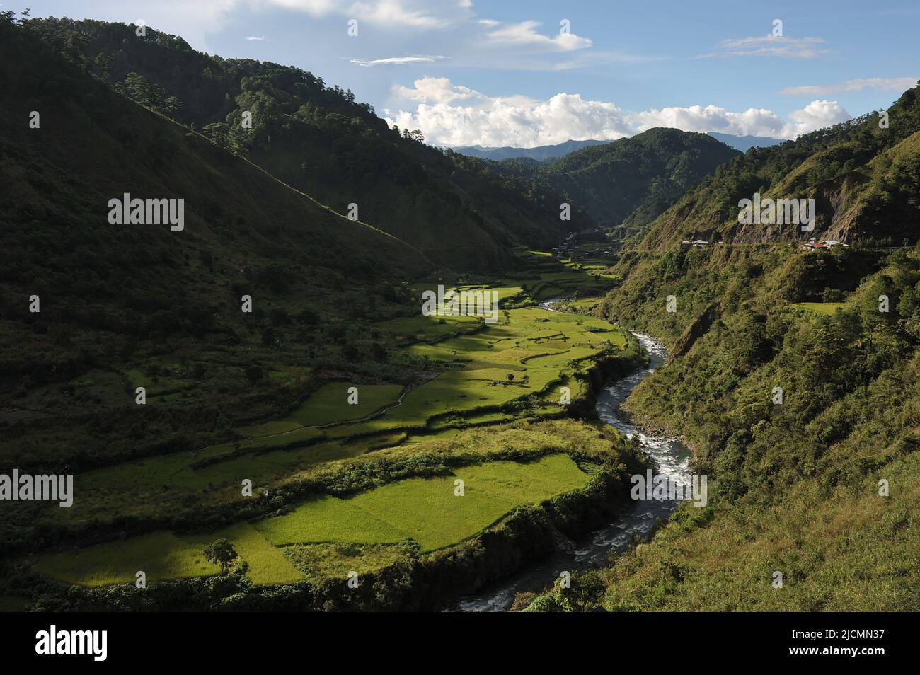 Mountain Province, Philippines: vibrant landscape of mountains surrounding rice fields beside a winding river on the road to Sagada from Batad. Stock Photo