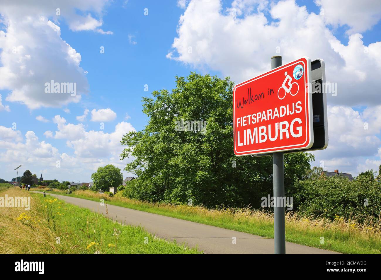 Uikhoven, Belgium - Juin 9. 2022: Red sign with message welcome to bicycle paradise limburg at cycling path in rural landscape of river Maas valley Stock Photo