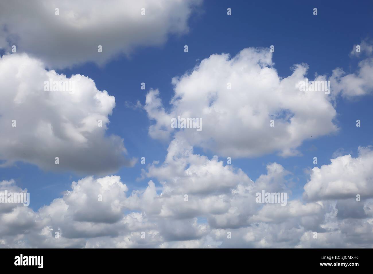 Isolated blue summer sky cloudscape photo with white fluffy fair weather cumulus clouds Stock Photo