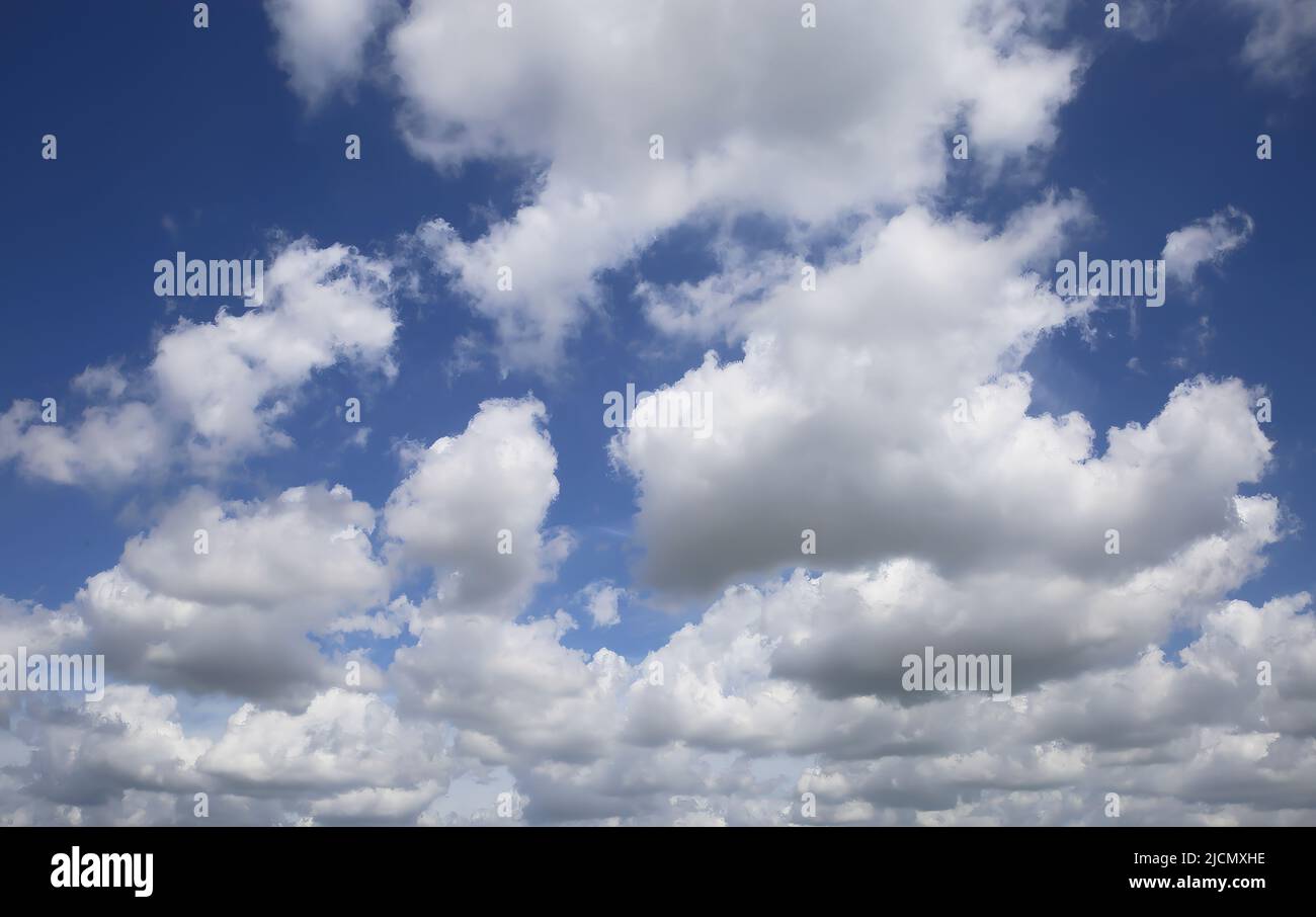 Isolated blue summer sky cloudscape photo with white fluffy fair weather cumulus clouds Stock Photo