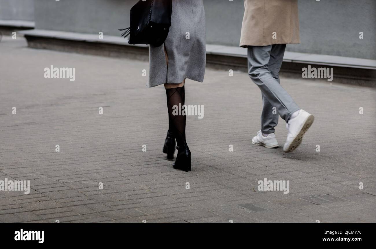 a couple in love is walking around the city. Close up on shoes Stock Photo