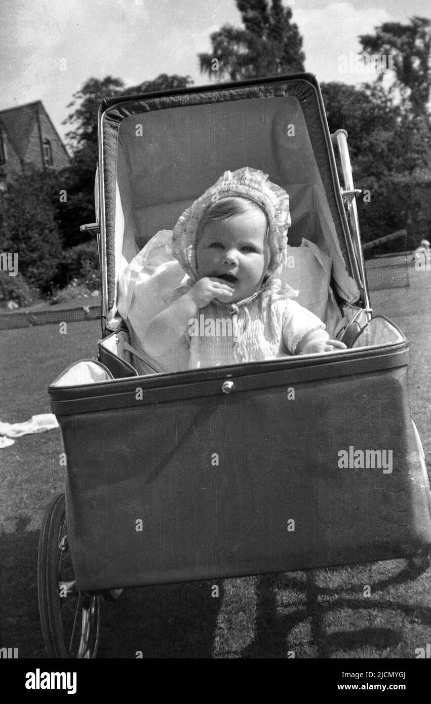 1950s, historical, front view of a little girl sitting in a pushchair ...