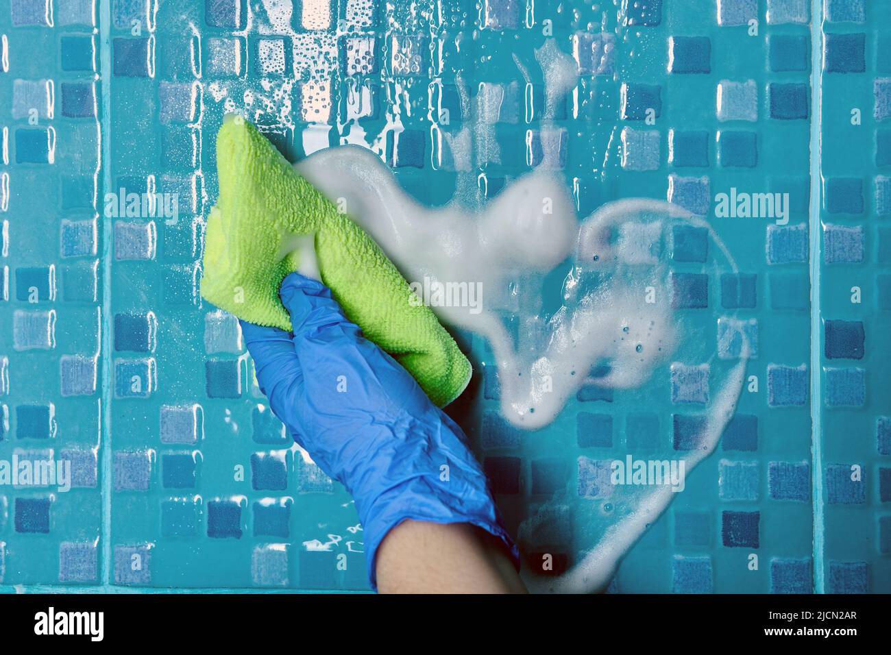 Microfiber cloth and cleaning agent are used to clean tiles in bathroom ...