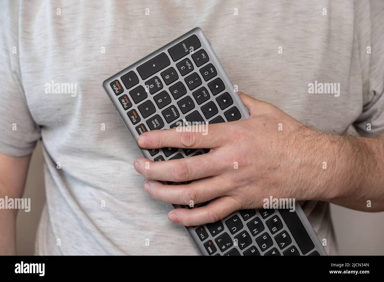 A middle-aged man is holding a keyboard for a notebook. Computer ...
