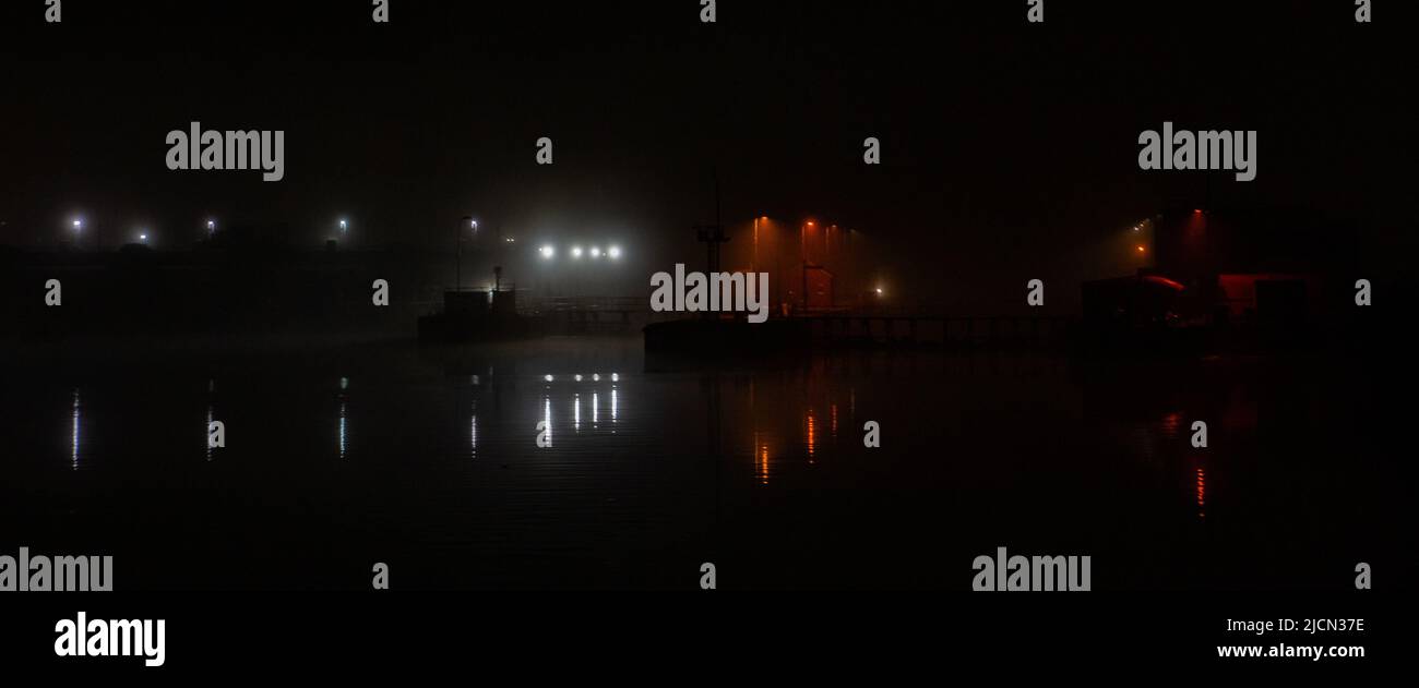 Foggy night creating an ominous effect, in Salford Quays, Manchester, Greater Manchester, United Kingdom. Stock Photo