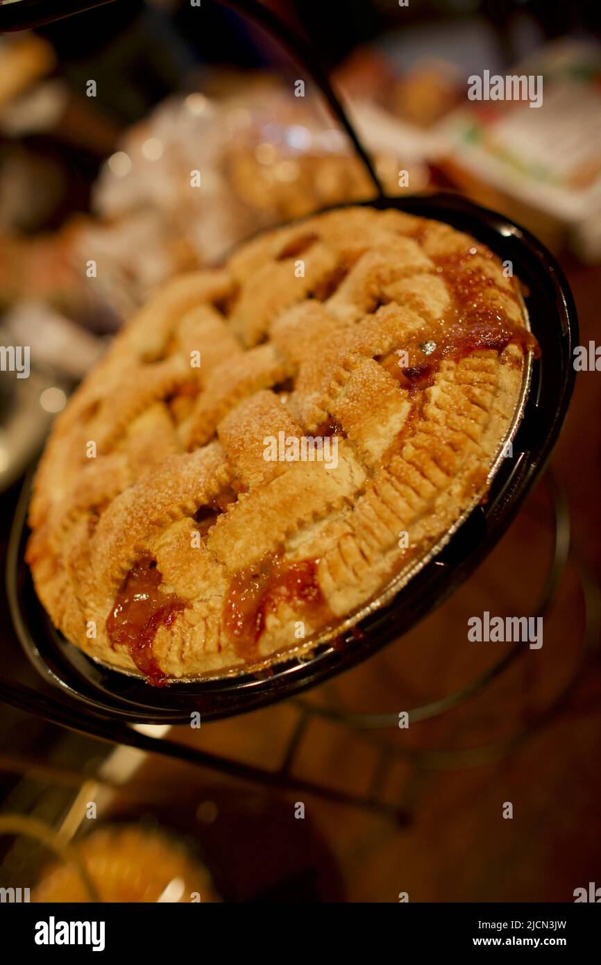 Whole Strawberry Rhubarb Pie decorated with lattice crust on a dark wooden table, landscape view from above, close-up, on angle. Stock Photo