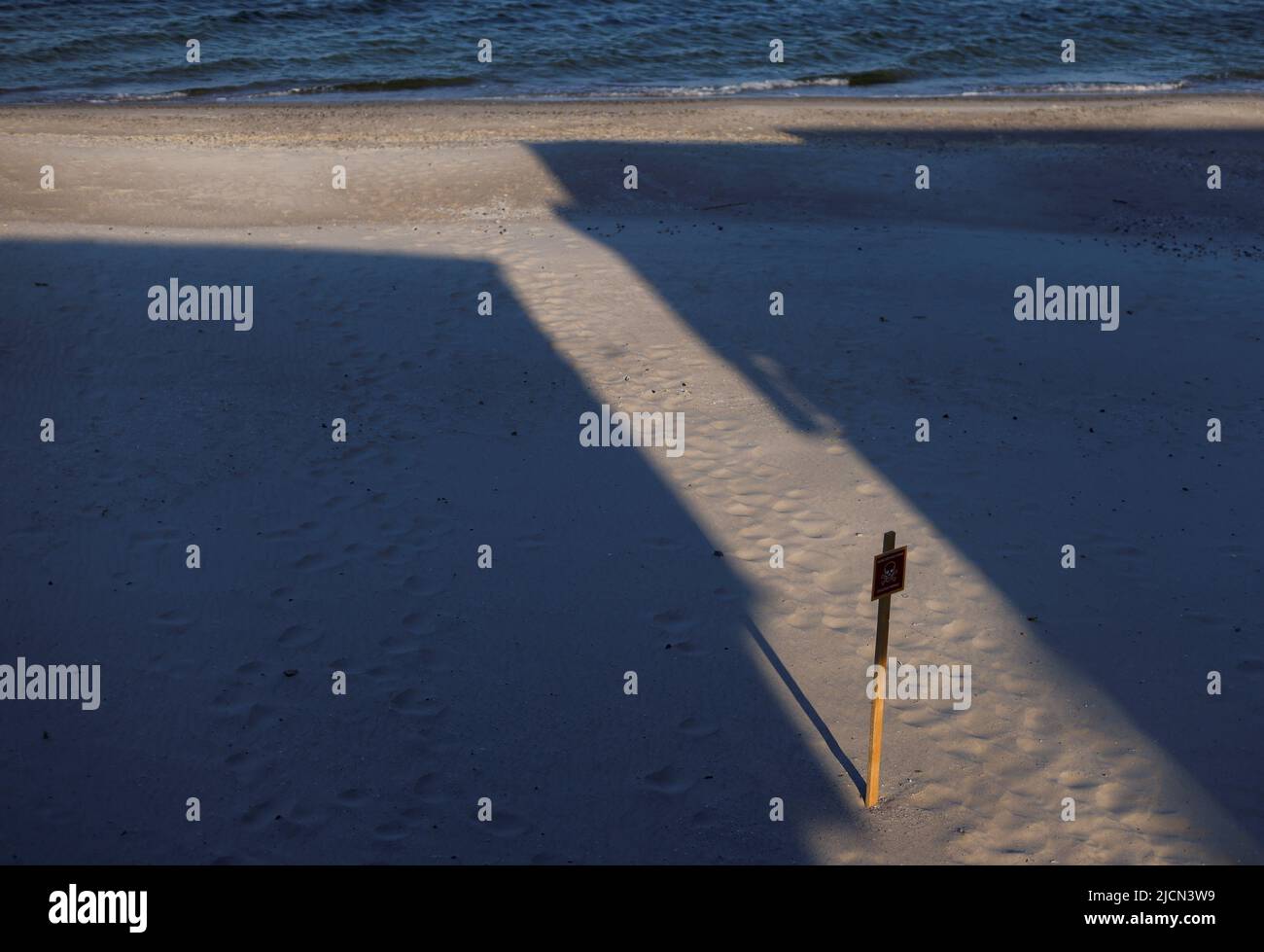 A sign warning beach goers of mines is seen in a closed off beach, as Russia's attack on Ukraine continues, in Odesa, Ukraine June 14, 2022.  REUTERS/Edgar Su Stock Photo