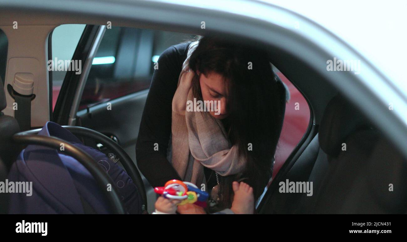 Mother securing her baby in the car seat of car Stock Photo Alamy