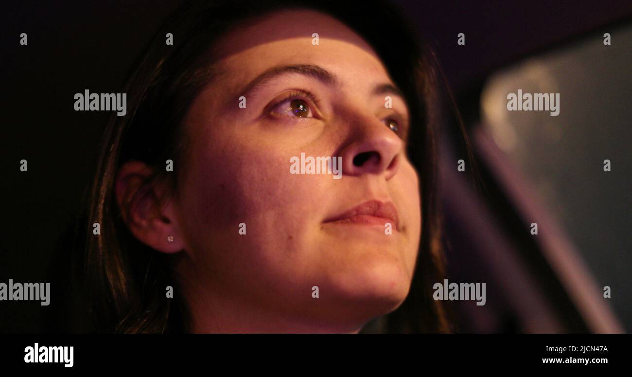 Portrait of woman driving at night in city, female driver looking at