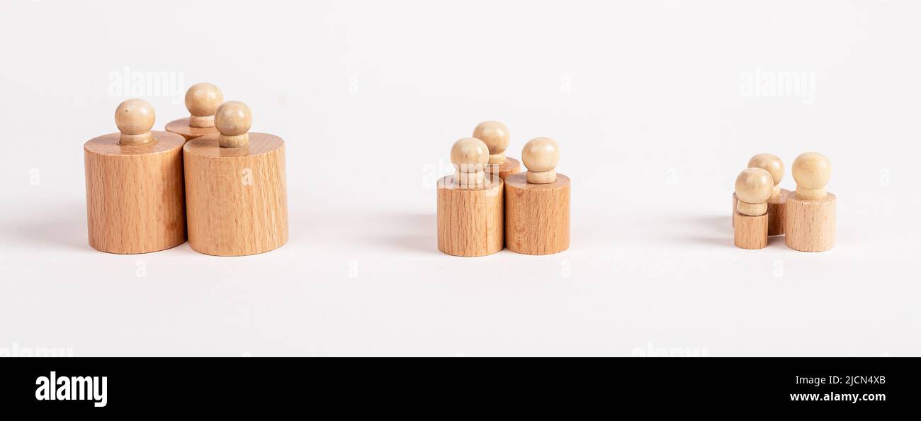 Row of Montessori knobbed cylinders placed in groups depending on size from bigger to smaller. Hierarchy, ranking, teamwork concept. Kids toy for development of dimension perception. photo Stock Photo