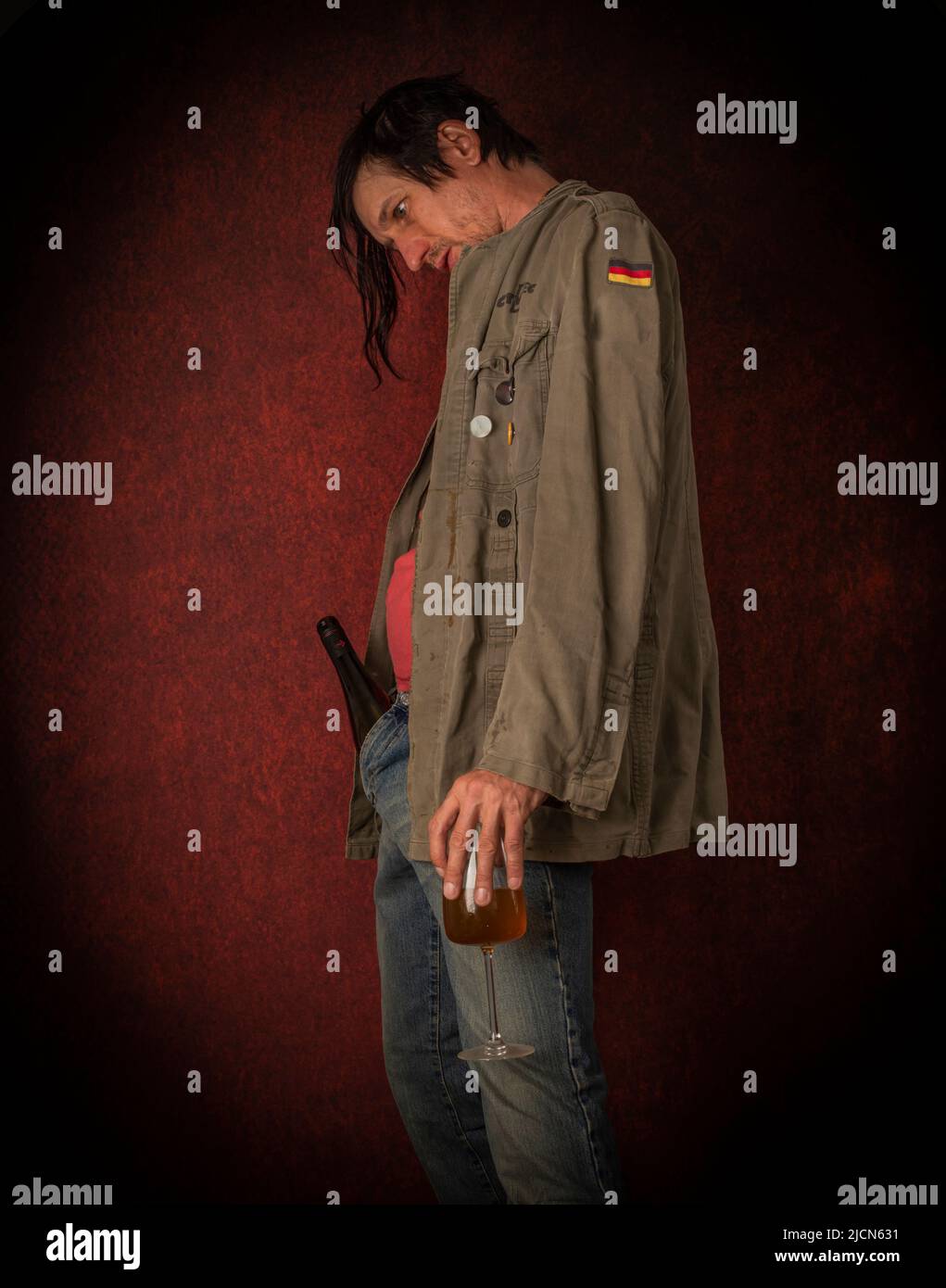 Junkie man with black hair and bottle with joint near vintage red wall Stock Photo Alamy