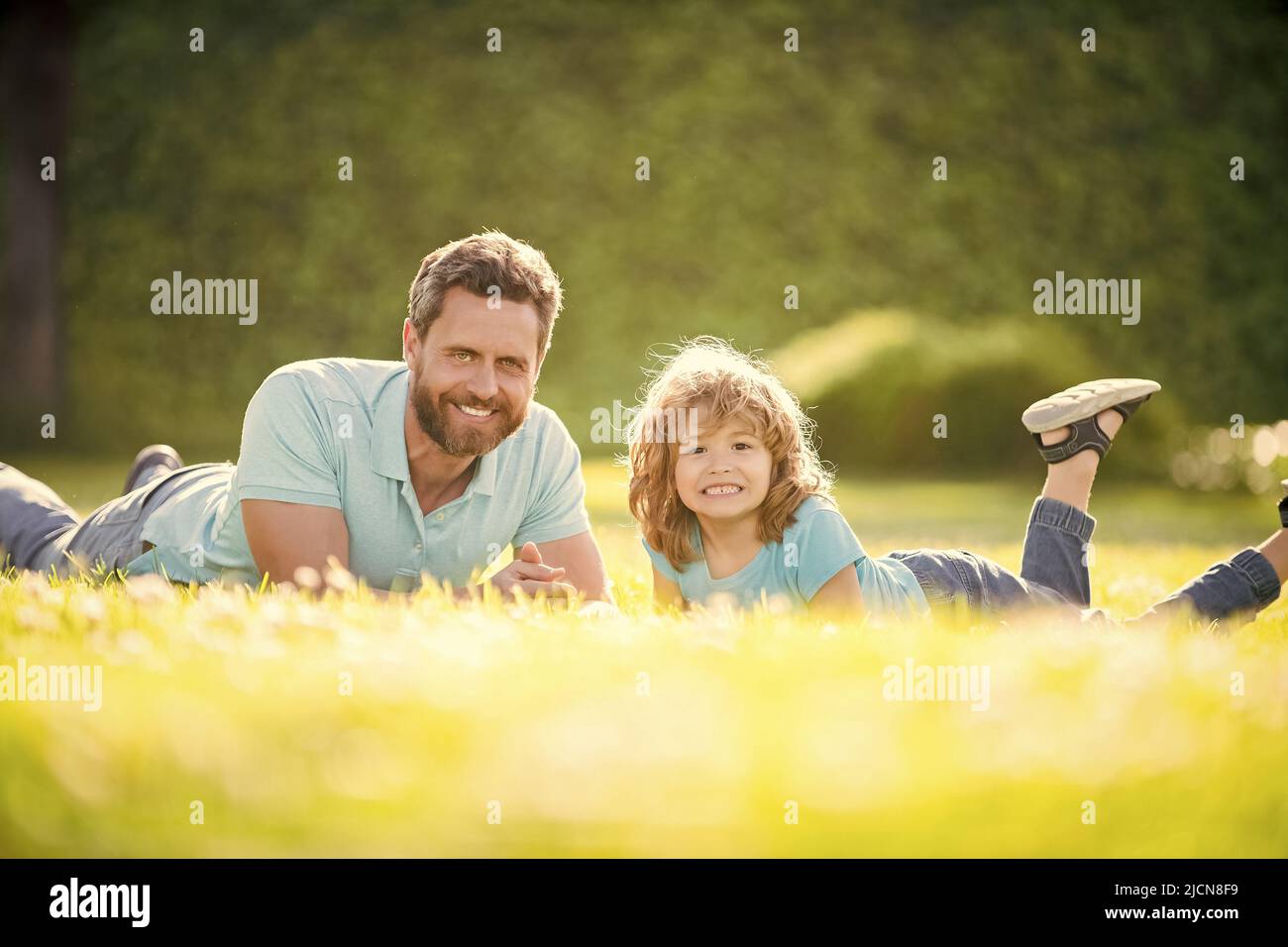 childhood and parenthood. parent relax with little child boy on grass. glad dad with kid Stock Photo