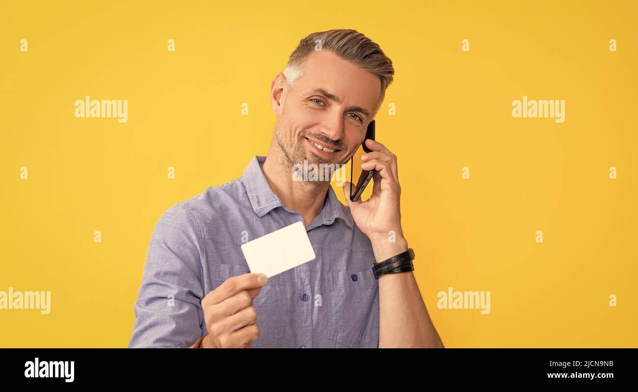 happy man speak on mobile phone showing debit card with copy space, identification Stock Photo
