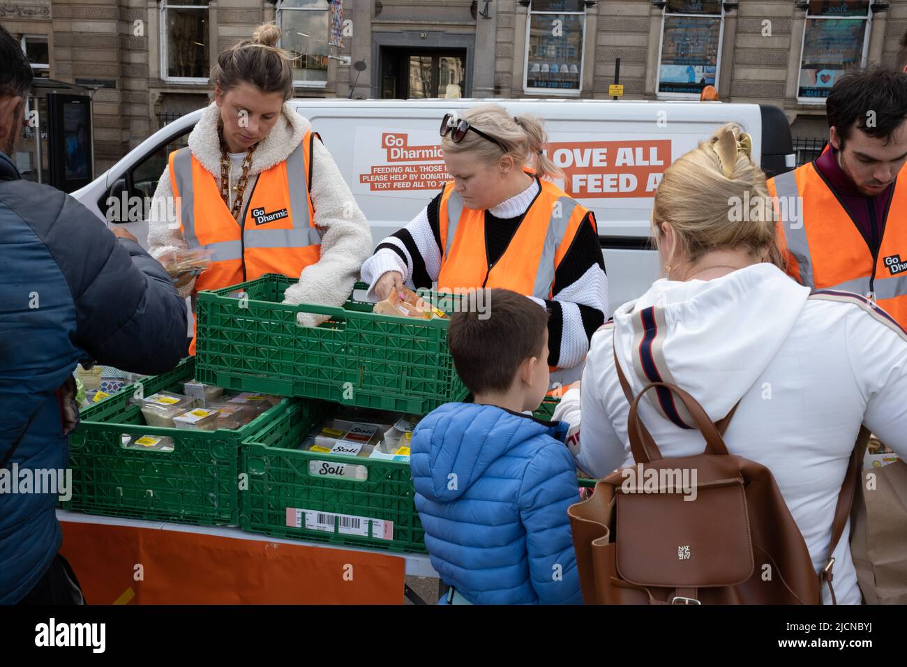 Glasgow, UK, 14 June 2022. People avail themselves of free food at at foodbank, run by the Go Dharmic #FeedEveryone campaign, which distributes 1000’s of meals across the country & strives towards minimising the #hunger crisis. A weekly event in George Square, in Glasgow, Scotland, on 14 June 2022. Photo credit: Jeremy Sutton-Hibbert/Alamy Live News. Stock Photo