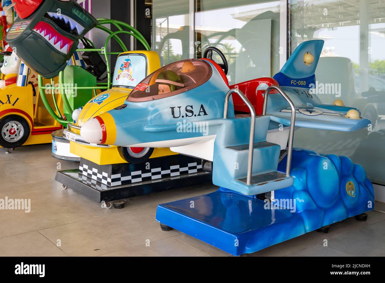 Colorful kiddie rides in front of a local store. Cyprus. Stock Photo