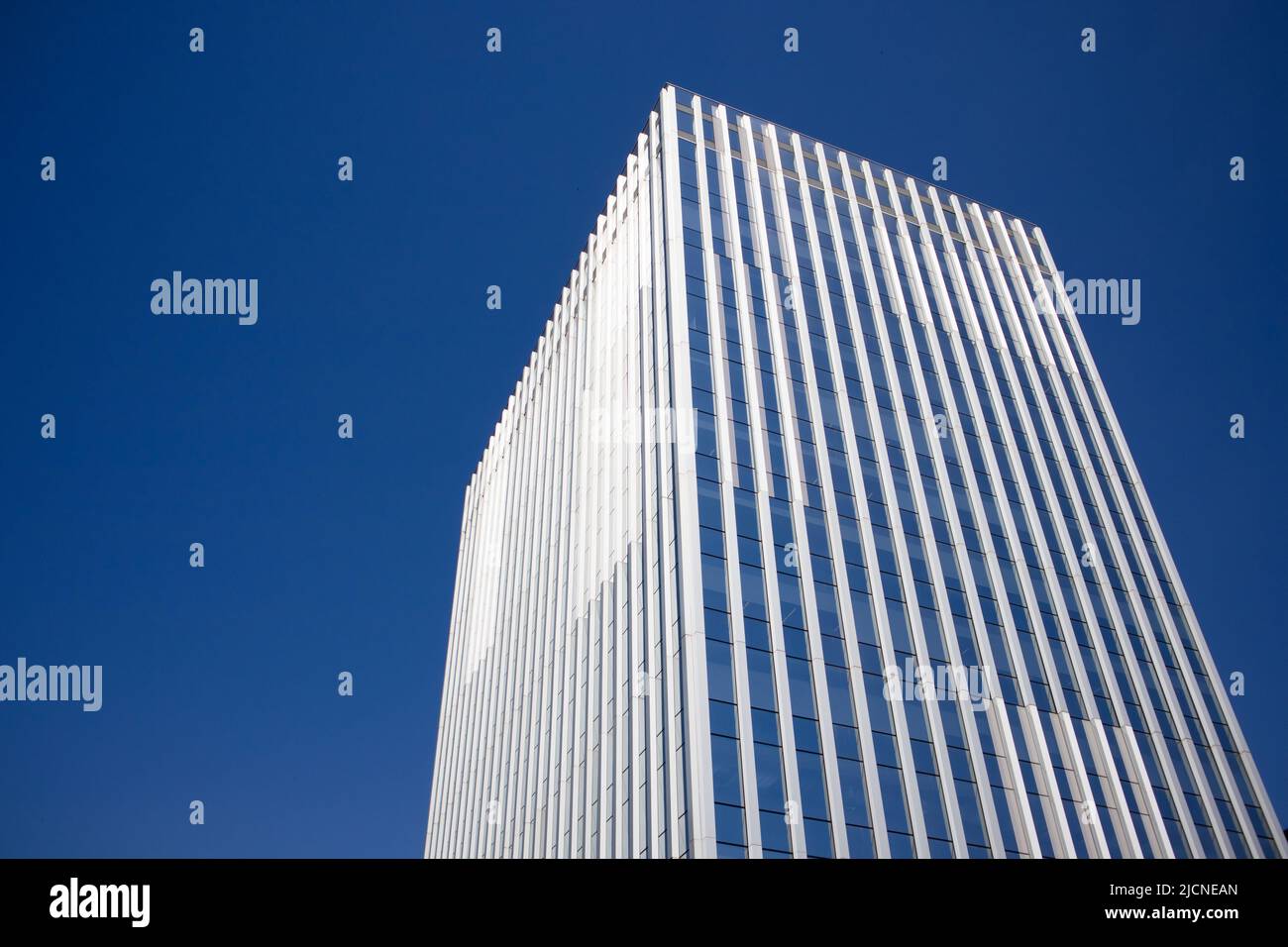Modern tall multistory building glass facade against blue sky ...