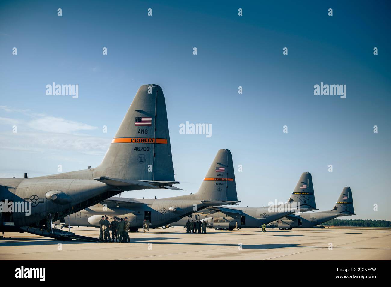 U.S. Air Force Airmen hold a mission brief behind a C130H Hercules