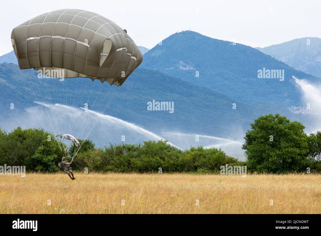 U.S. Army paratroopers with the 173rd Brigade Support Battalion, 173rd Airborne Brigade, exit a CH-47 Chinook during an airborne operation at Juliet Drop Zone, Italy, June 9, 2022. Families of the paratroopers were invited to witness their jump. The 173rd Airborne Brigade is the U.S. Army's Contingency Response Force in Europe, providing rapidly deployable forces to the United States European, African, and Central Command areas of responsibility. Forward deployed across Italy and Germany, the brigade routinely trains alongside NATO allies and partners to build partnerships and strengthen the a Stock Photo