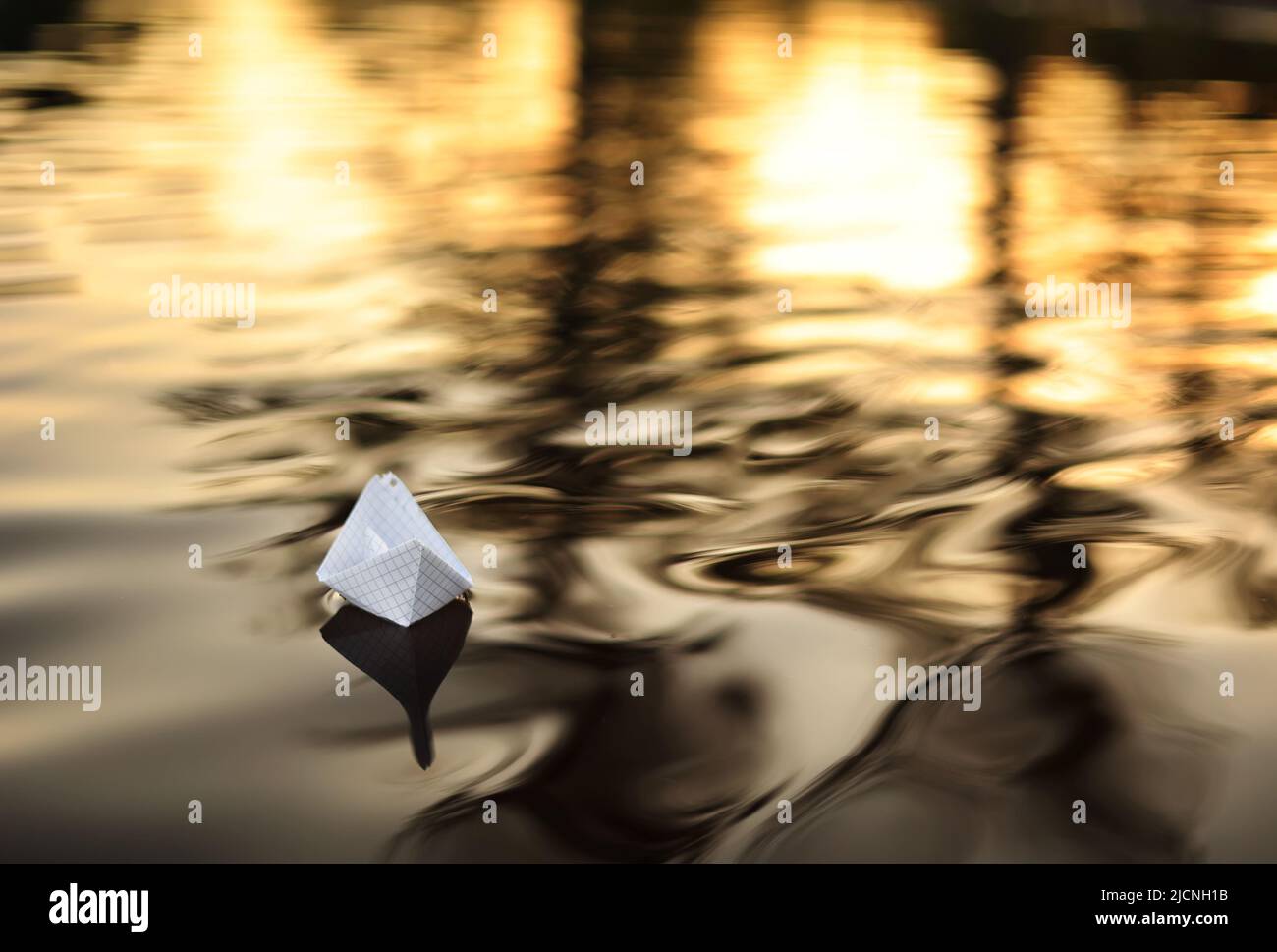 A paper boat is floating on the waves in the water at a beautiful
