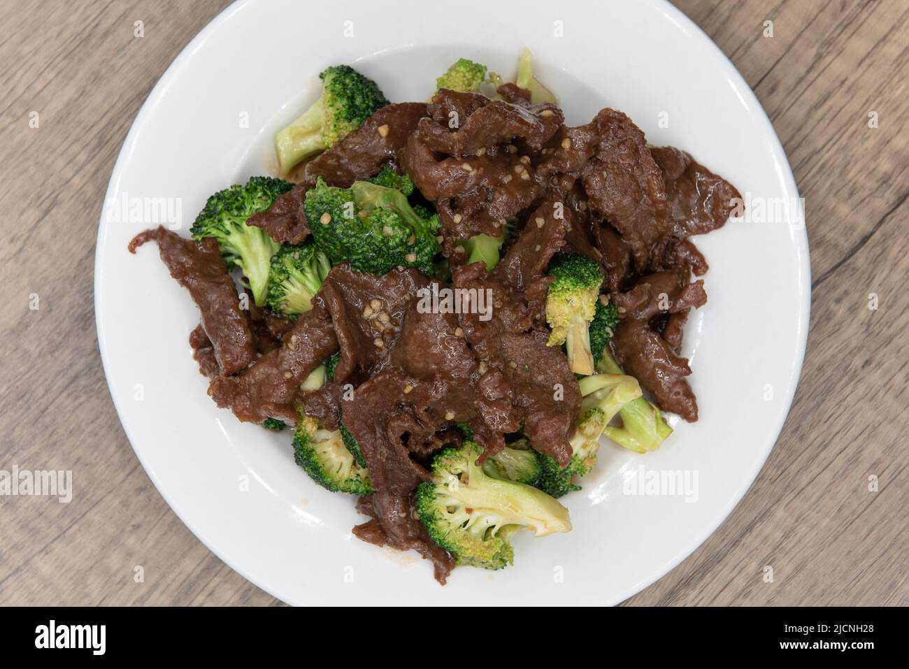 Overhead view of beef and broccoli glazed in savory sauce and piled high on the plate for a great Chinese food meal. Stock Photo
