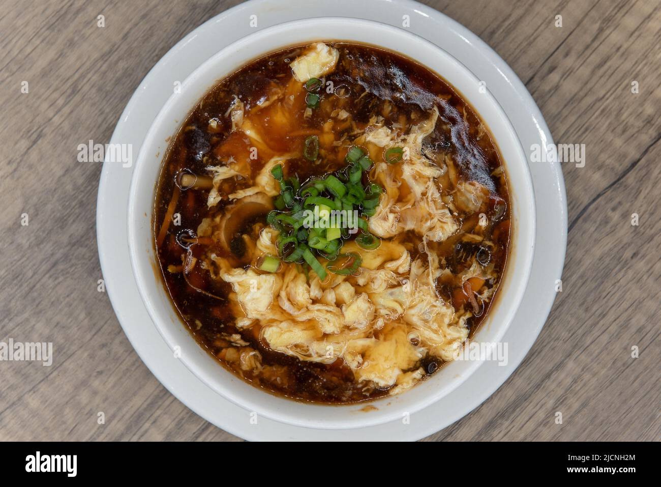 Overhead view of spicy and generous bowl of hot and sour soup for a hearty Chinese food meal. Stock Photo