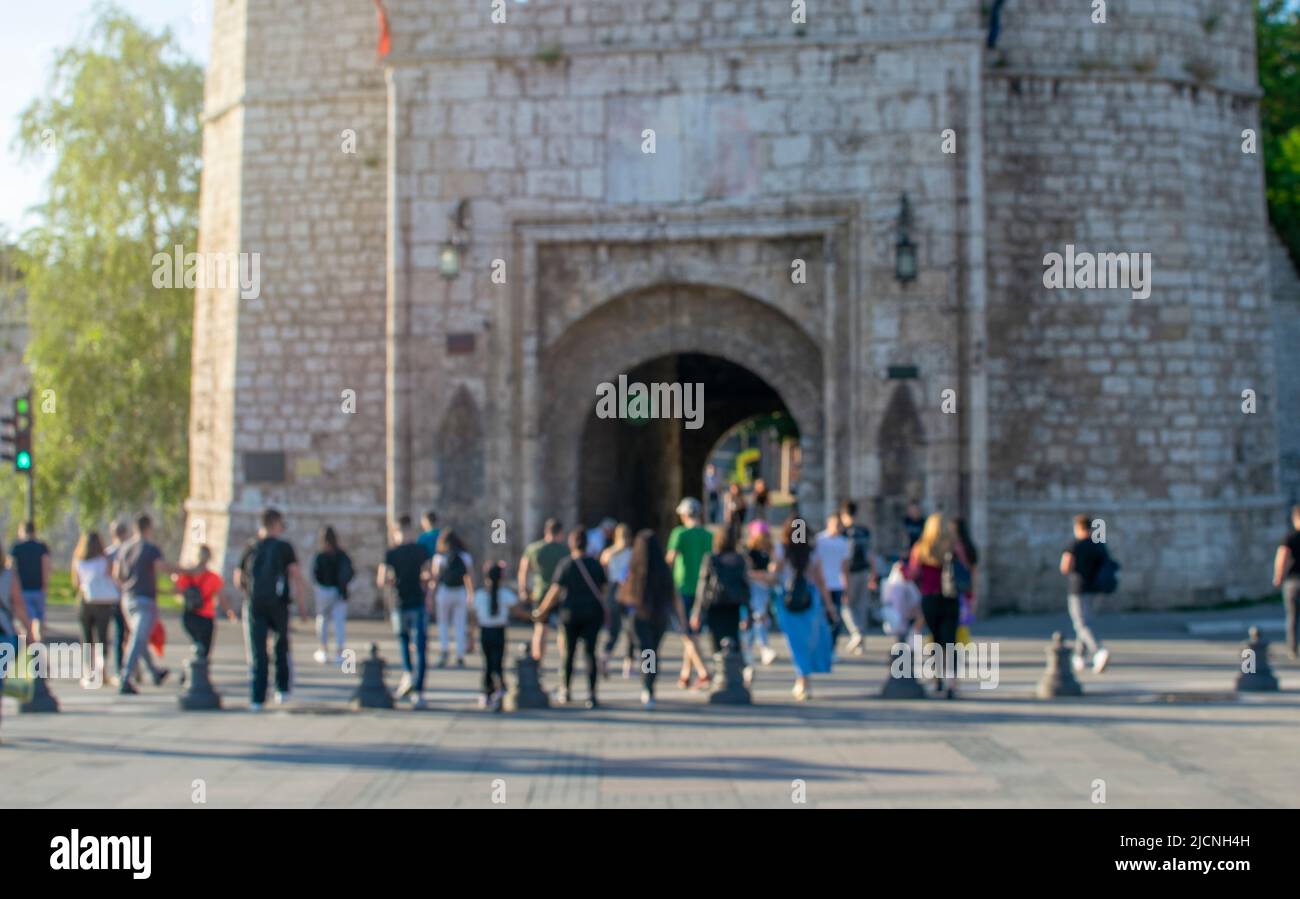 Blurred motion of crowd pedestrians crossing street in pedestrian walkway against urban buildings with city scene Stock Photo