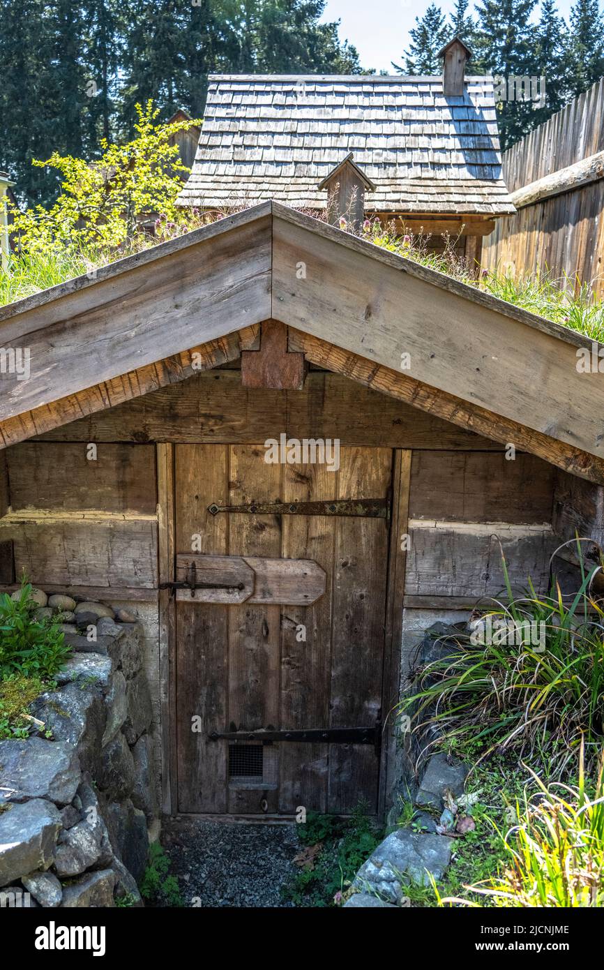 Root storage building used to store potatoes during the summer with the smoke house in the background at the Fort Nisqually Living Museum in Tacoma, W Stock Photo