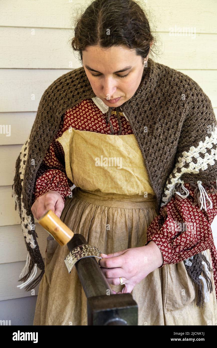 woman working with tin while wearing authintic clothing from the 1850s at Fort Nisqually Living Museum in Tacoma, Washington Stock Photo