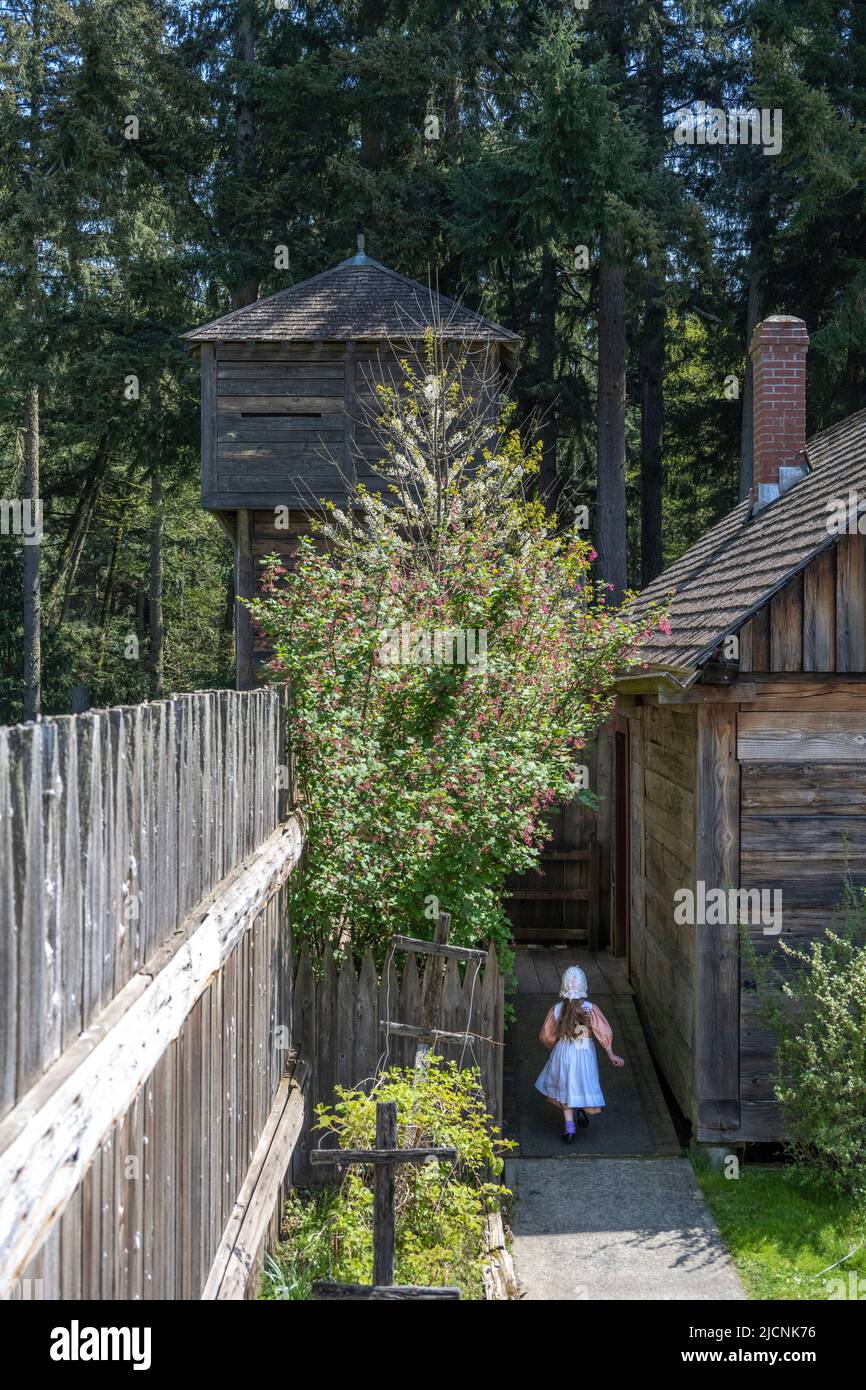 small girl dressed in traditional 1850s clothing at the Fort Nisqually Living History Museum in Tacoma, Washington Stock Photo