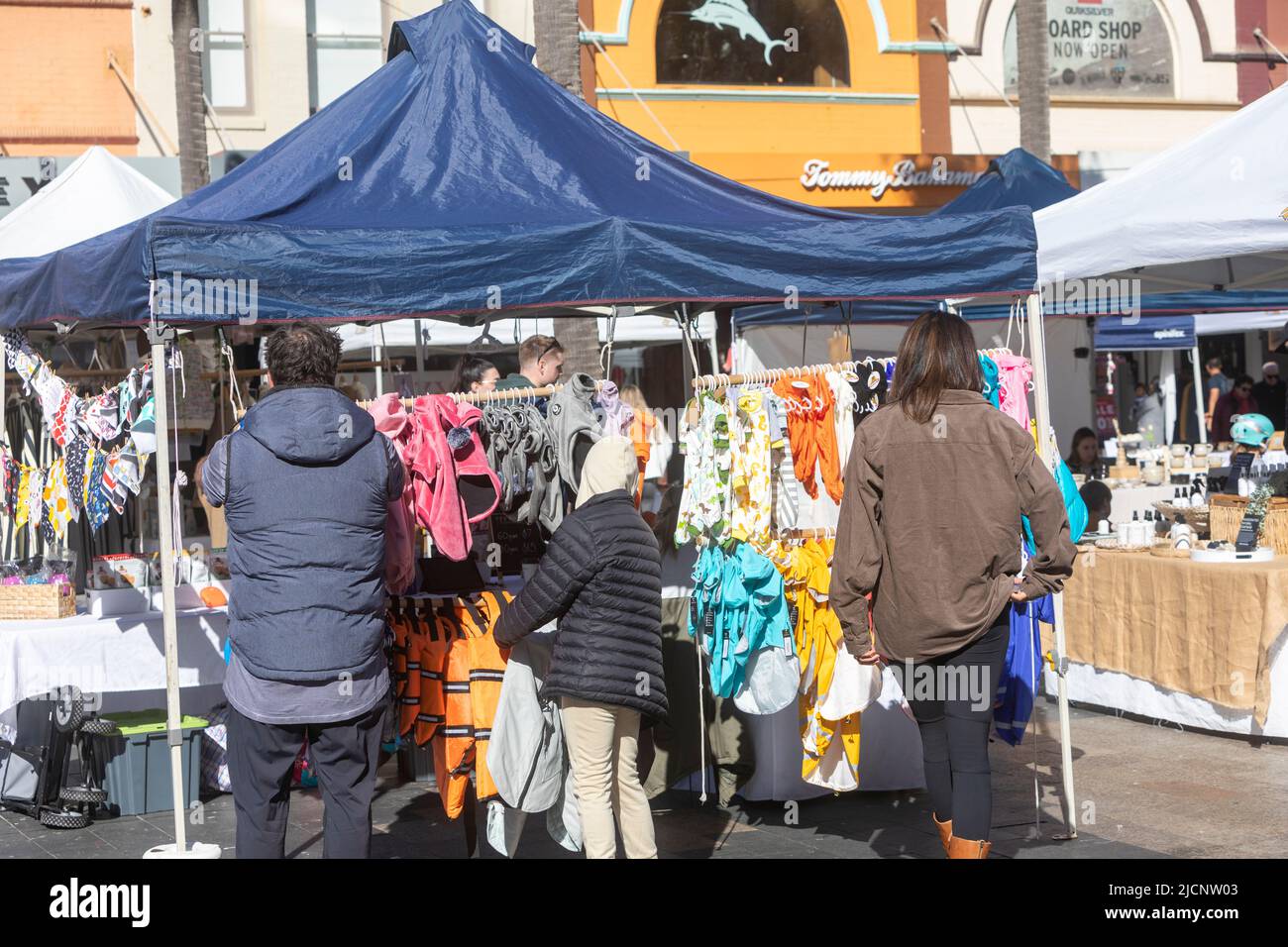 Stallholder at Manly markets in Sydney, shoppers browse the clothes for sale on the stall,Sydney,Australia Stock Photo