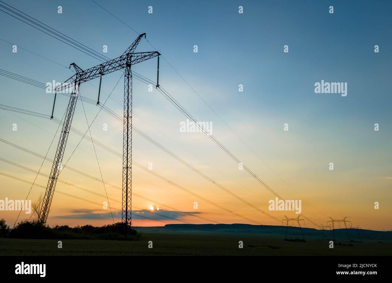 High voltage towers with electric power lines at sunset Stock Photo - Alamy