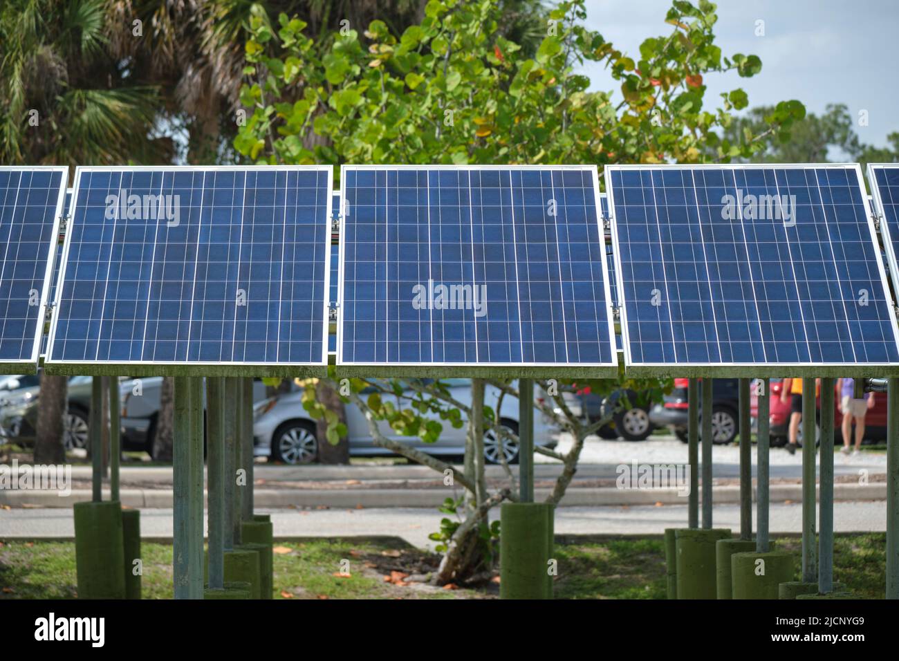 Solar panels installed on stand frame near parking lot for effective generation of clean electricity. Photovoltaic technology integrated in urban Stock Photo