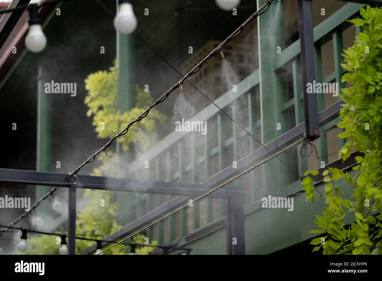 Automatic water spray system to create a cooling effect in hot weather