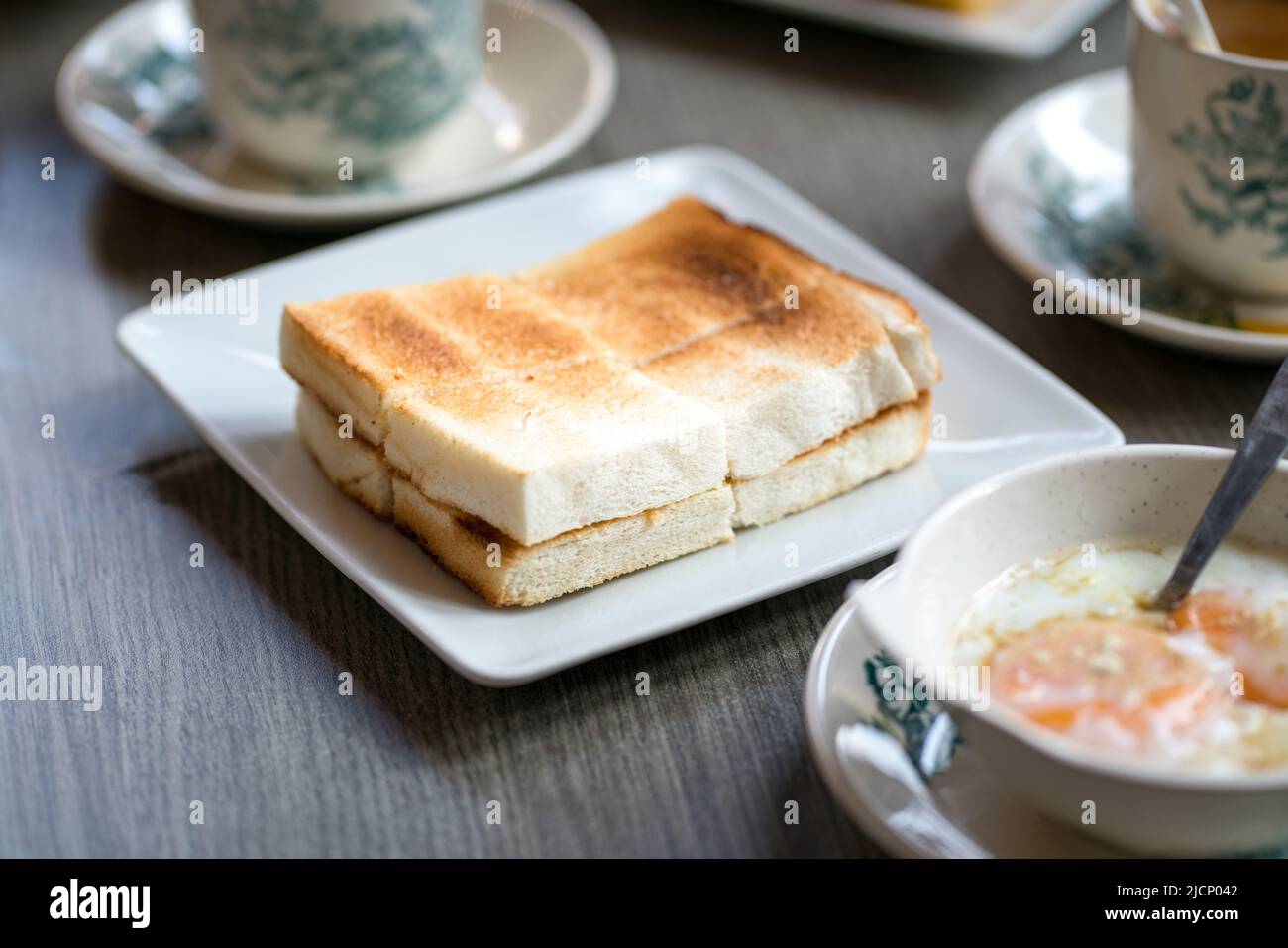 Oriental traditional Hainanese breakfast set with toast bread, half boiled eggs and coffee. Stock Photo