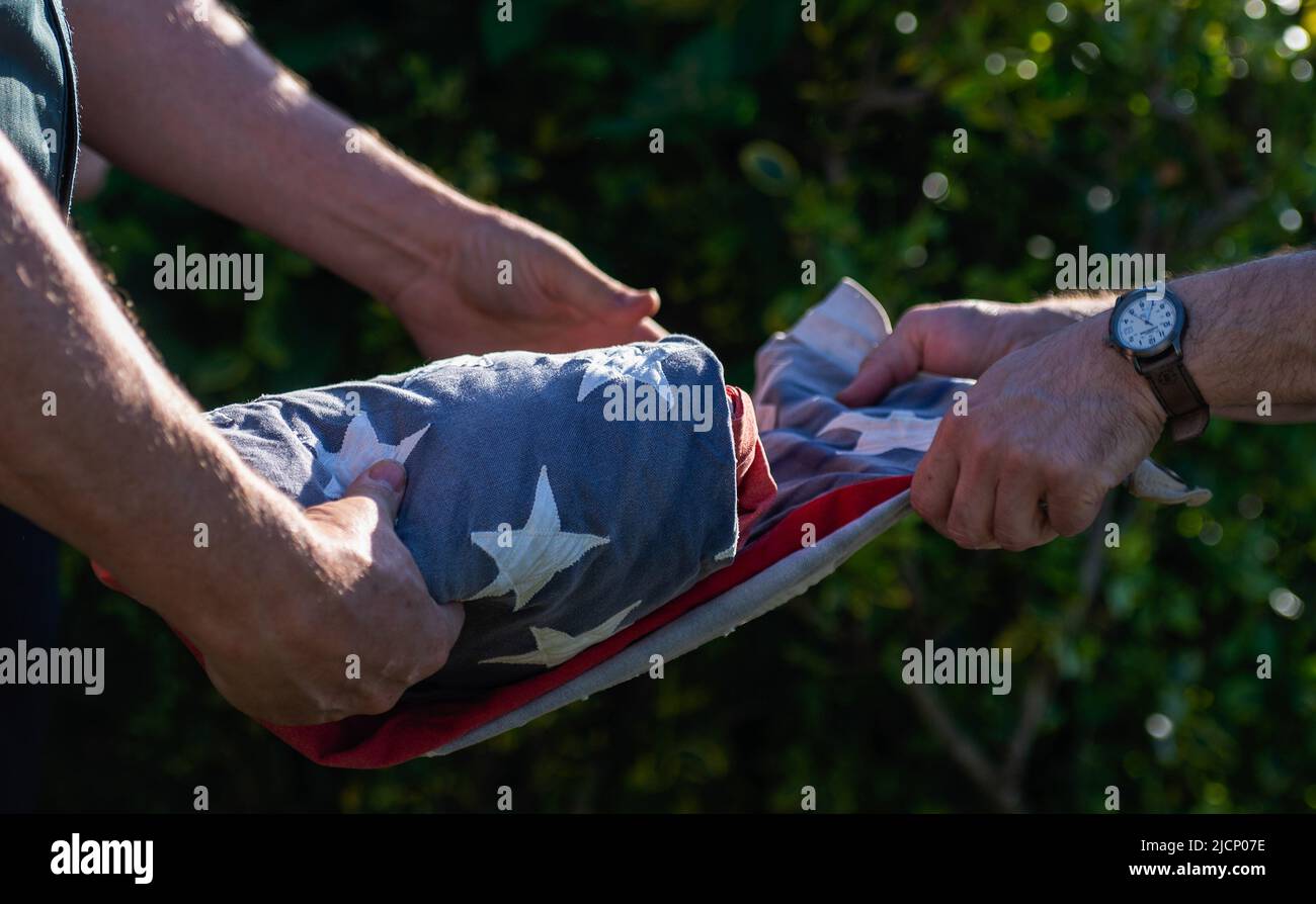 Two members of the Boy Scouts fold a flag to be retired at a ceremony ...