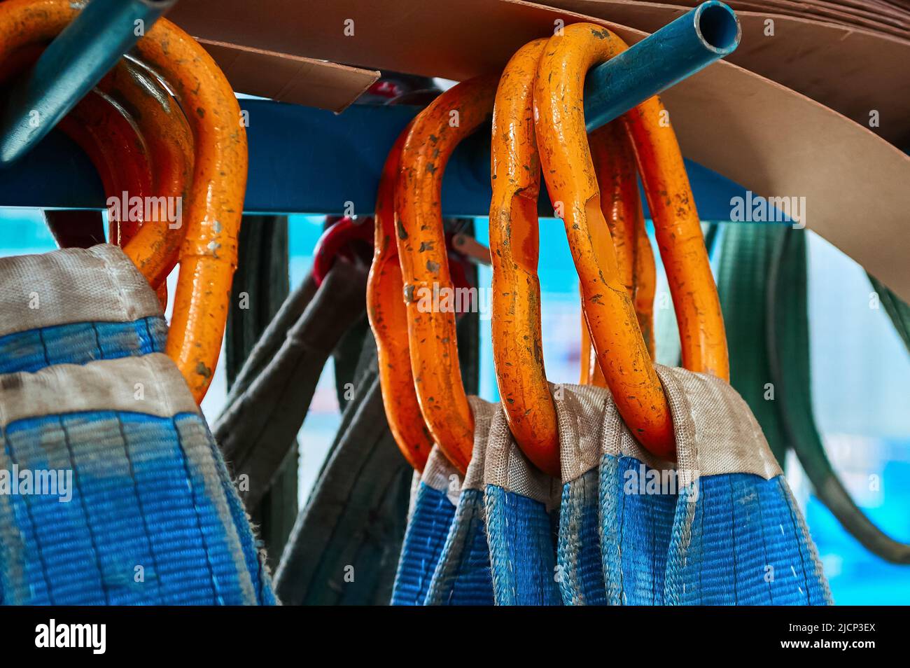 Rigging equipment with textile strops hangs on rack hooks Stock Photo