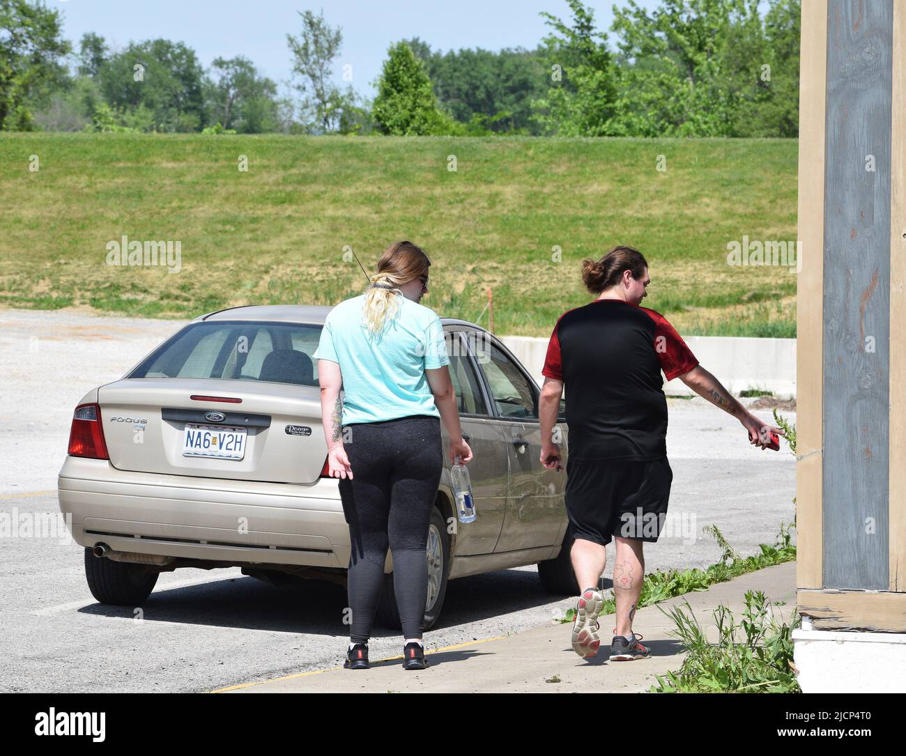 Tattooed or tatted man and woman walking down a street in a midwestern American town Stock Photo