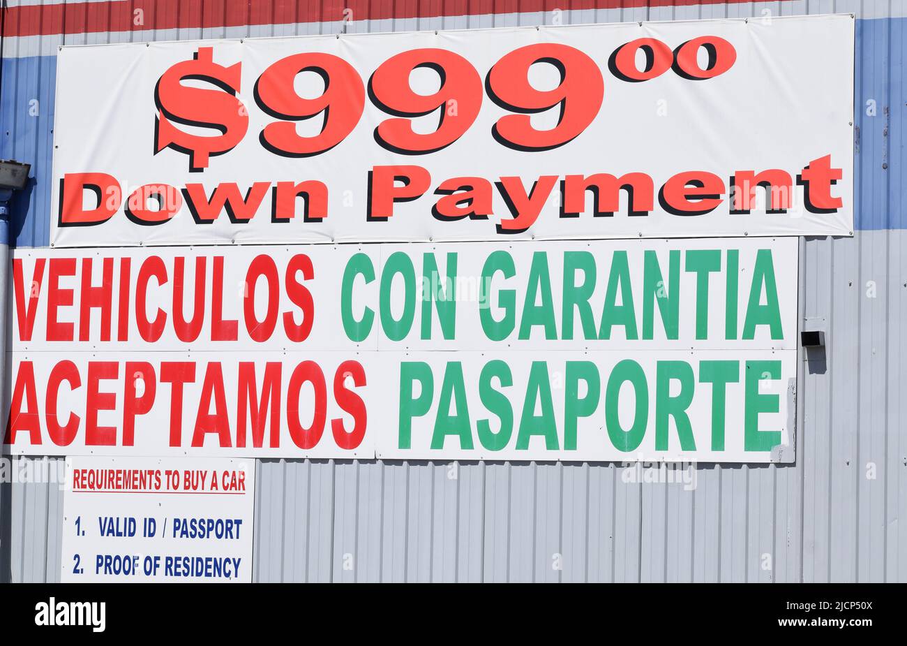Close up of bilingual signage at a used car dealer Stock Photo