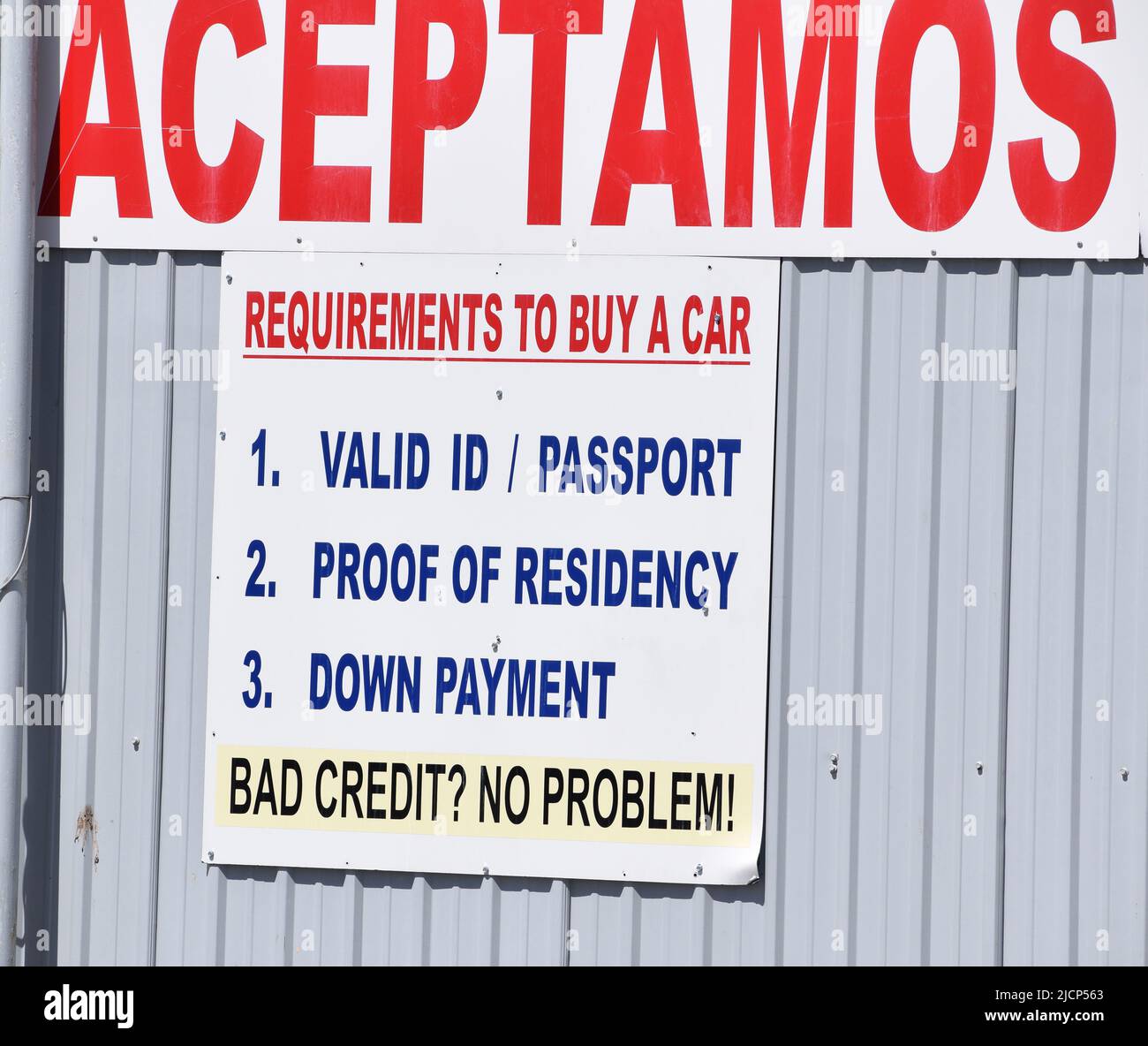 Close up of bilingual signage at a used car dealer Stock Photo